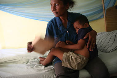 A mother holds her child, who has dengue fever
